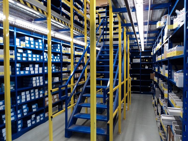 Entrepôt de pièce présenter à l'aide d'étagère métallique et d'une mezzanine.