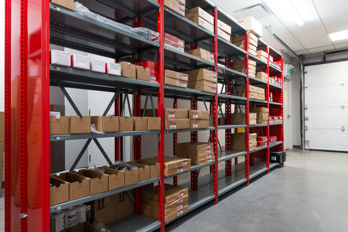 Grey and red industrial shelving in a KIA dealership.