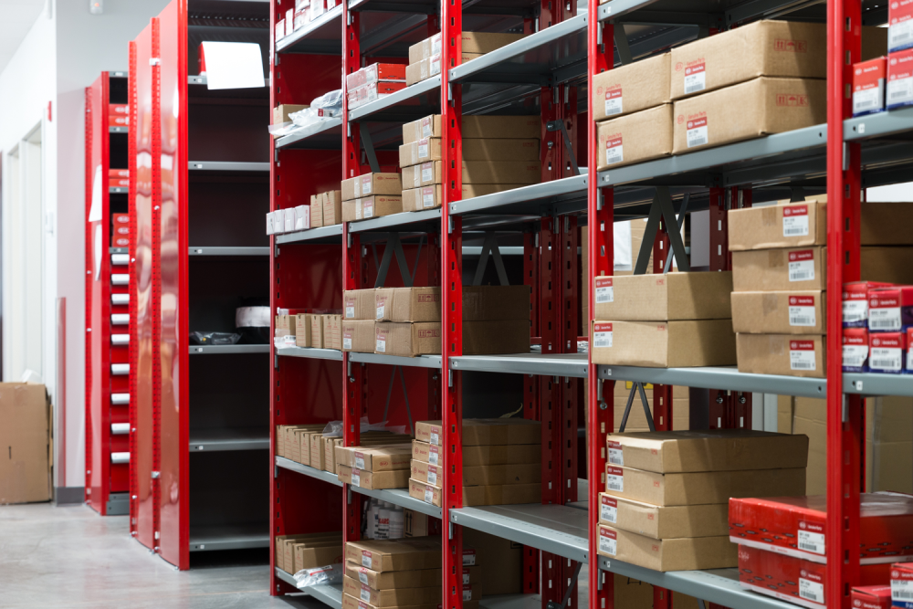 Grey and red industrial shelving in a KIA dealership.