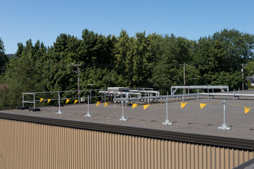 Warning line with yellow flags installed on a flat roof.