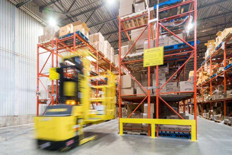 A forklift operating within a VNA (Very Narrow Aisle) storage system.