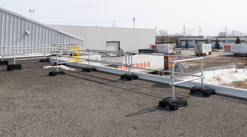 Un système de garde-corps avec barrière coulissante pour livraison de matériel sur un toit.