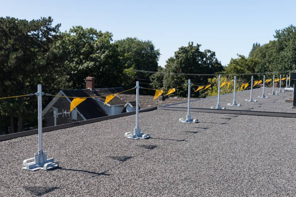 Warning line with yellow flags installed on a flat roof.