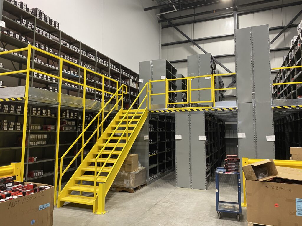 Une mezzanine grise et jaune dans un magasin de pièce automobile.
