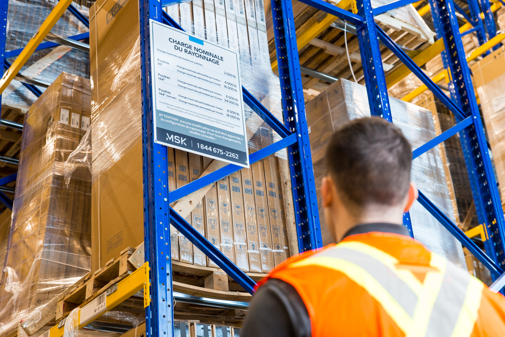 An inspector reviewing the capacity charts of a pallet rack.
