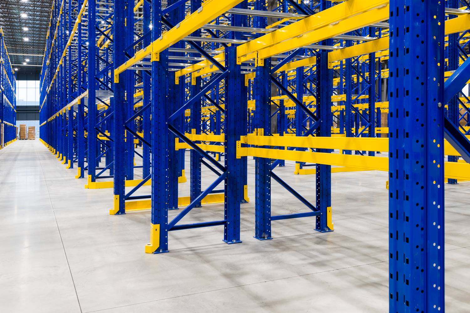Palettiers bleu et jaune dans un entrepôt.